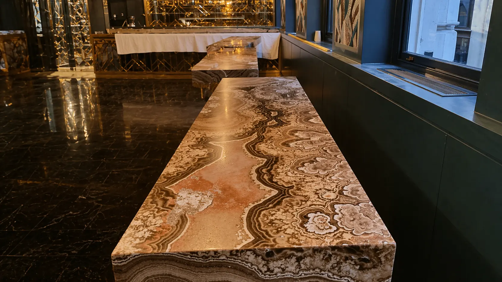 Backlit onyx bar counter showing dramatic amber, cream and cognac banding in a luxury London venue