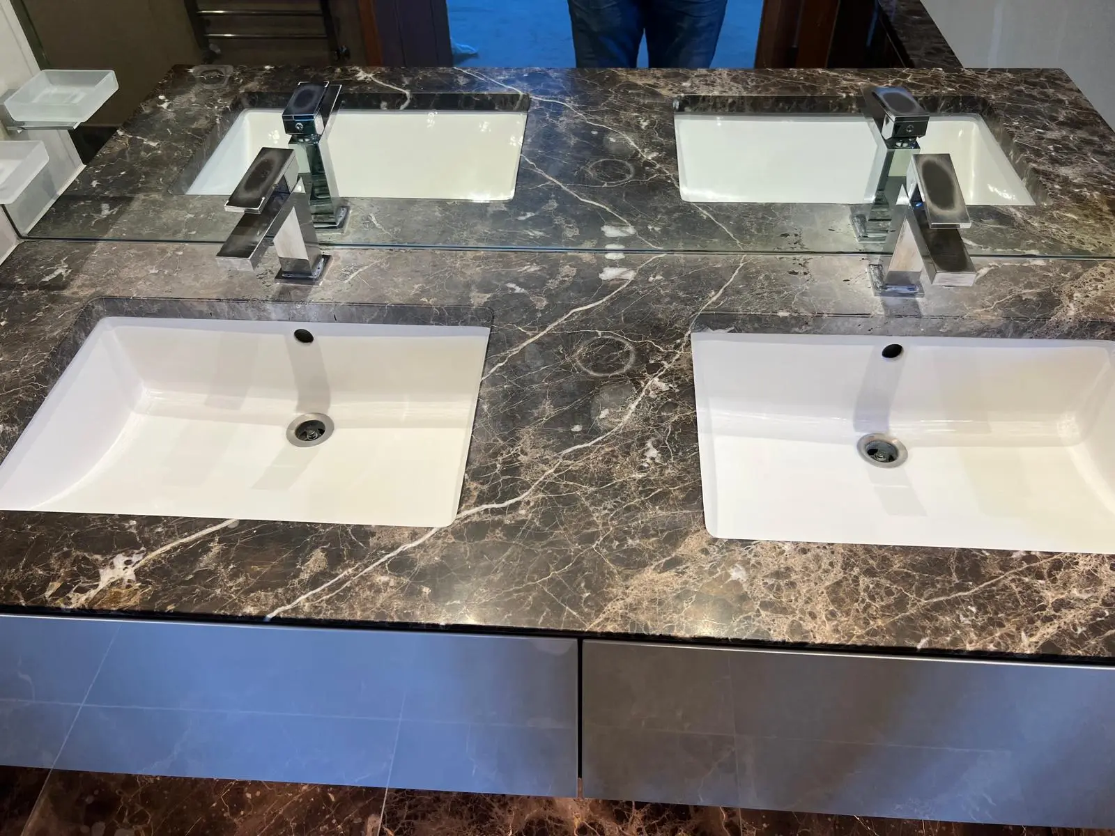 Marble bathroom vanity before restoration, dull, etched and water-marked surface around twin basins, London