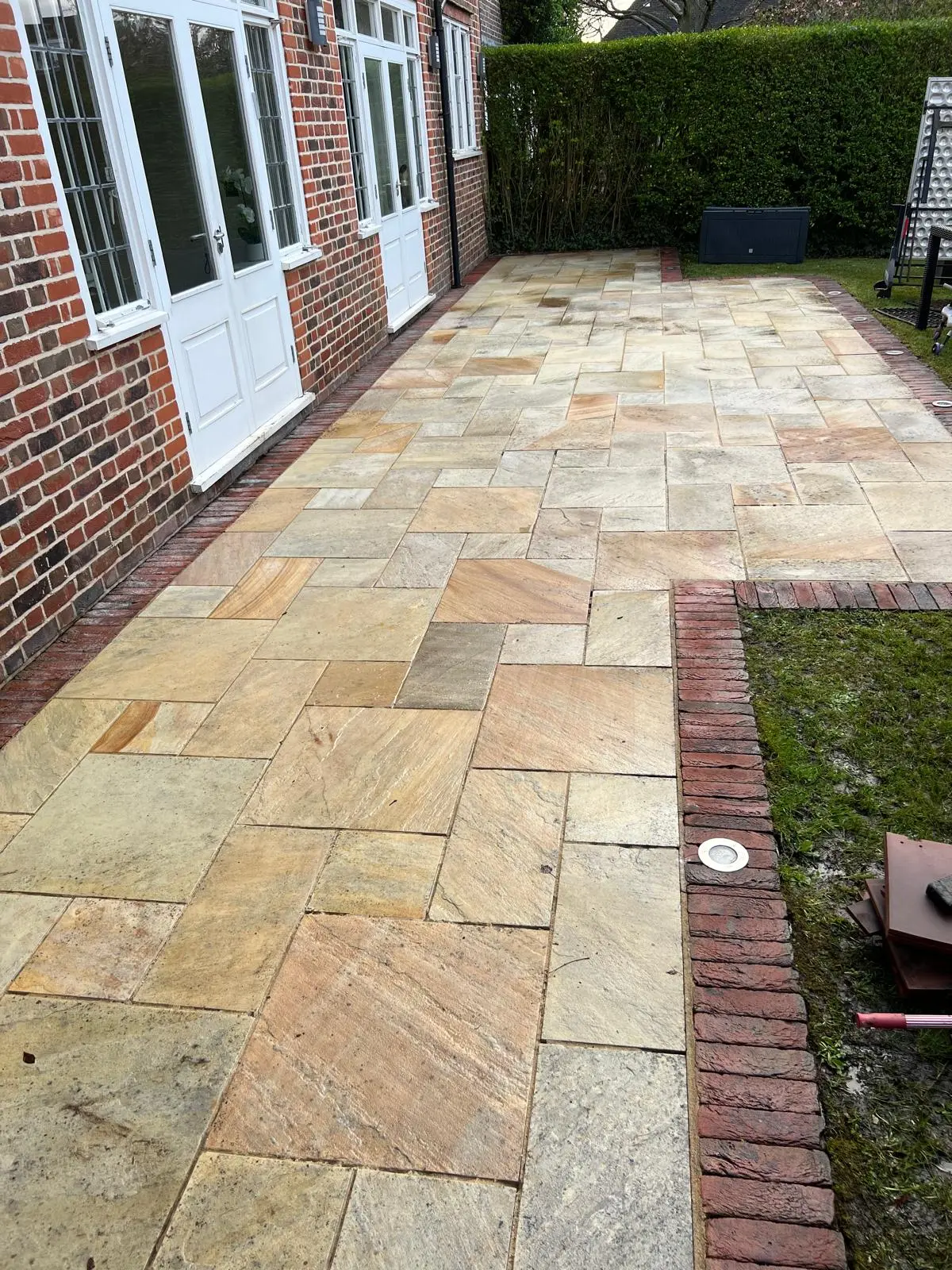 Stone patio after restoration, deep-cleaned and resealed, even tone restored across the slabs