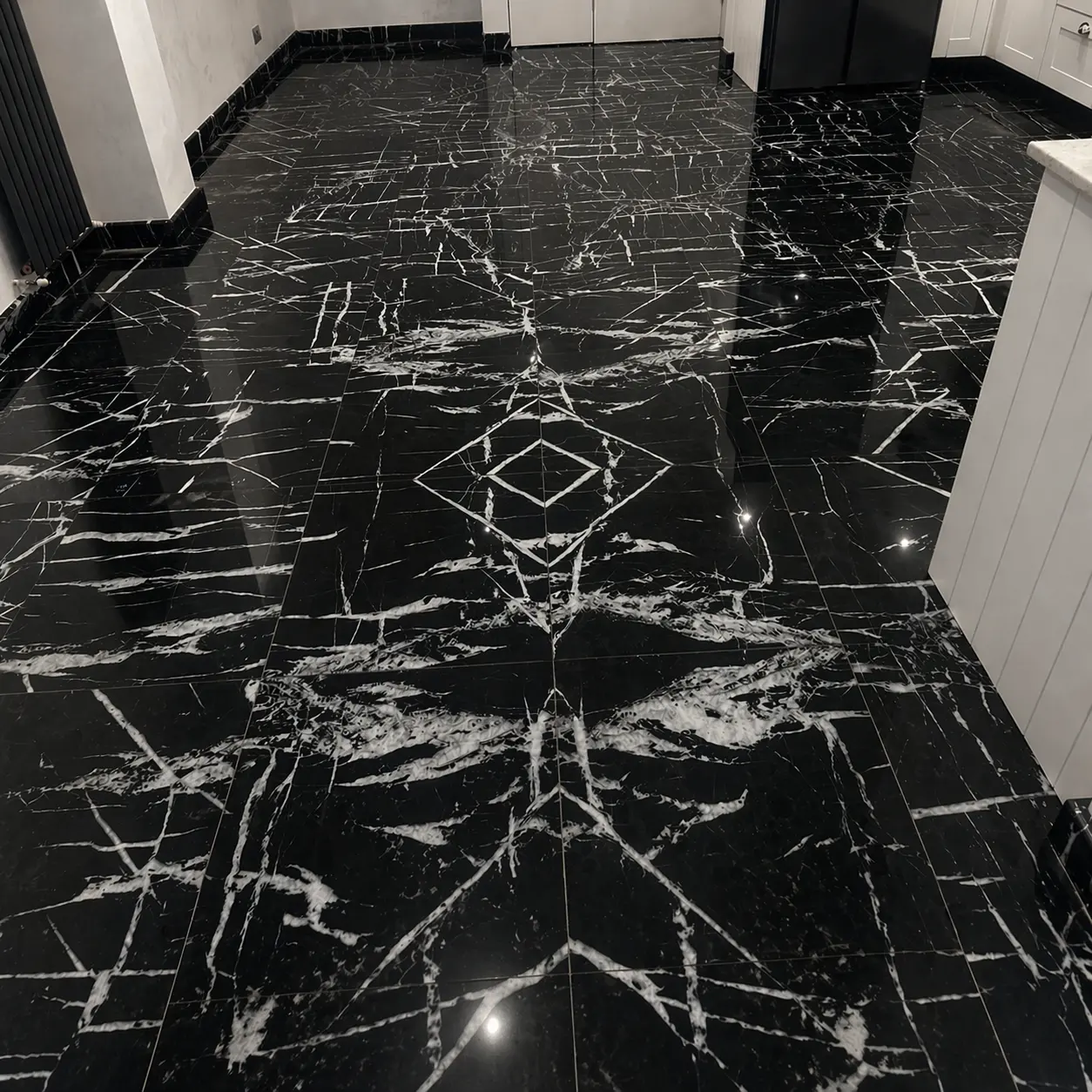 Same Nero Marquina black marble kitchen floor after polishing, deep reflective mirror finish with veining fully revealed