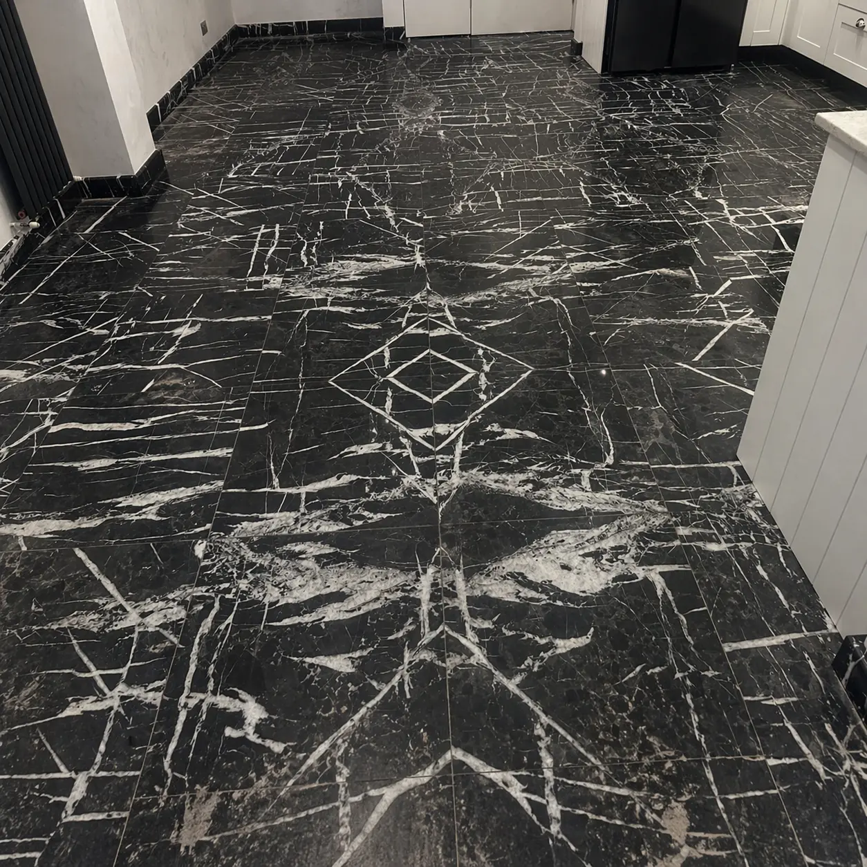 Nero Marquina black marble kitchen floor before polishing, surface dull and showing wear